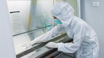 A Scientist In Sterile Coverall Gown Using Alcohol 70% And Clean